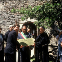 Assisi Dedication 1991 TJ is dedicating a plaque to a men wearing Italian sash