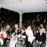 International Day of Peace 2010 men and women in festive clothes throwing rose petals in the air at nighttime