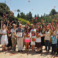 Lake Shrine 2012 men, women and children throwing rose petals in the air