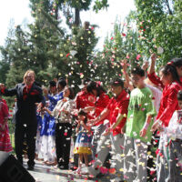 State Capitol 10 Year Anniversary, 2013 TJ and people in festive clothes throwing rose petal in the air