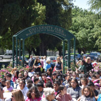 University Park Dedication Day 2015 People in colorful clothes gathered under an arch and celebrating