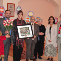 Presentation of Plaque & Roses to Muslim Community men and women holing a plaque and roses