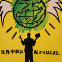 Japan A shape of a man standing under a green planet Earth with white wings attached to it